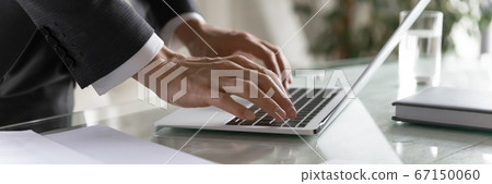 Panoramic view of businessman typing on laptop keyboard Panoramic view of businessman typing on laptop keyboard 67150060