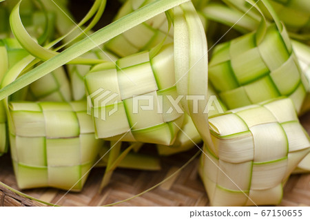 ketupat casing and rice in bamboo container. 67150655