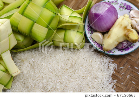ketupat casing and rice in bamboo container. ketupat casing and rice in bamboo container. 67150665