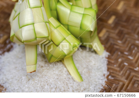 ketupat casing and rice in bamboo container. ketupat casing and rice in bamboo container. 67150666