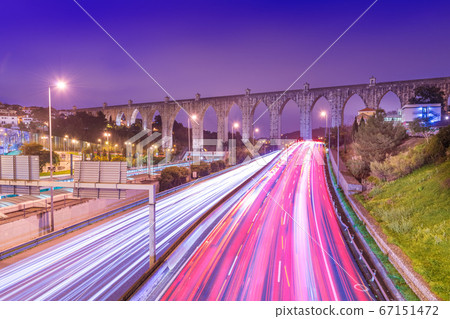View of highway with car traffic and light trails. The Aguas Livres Aqueduct 67151472