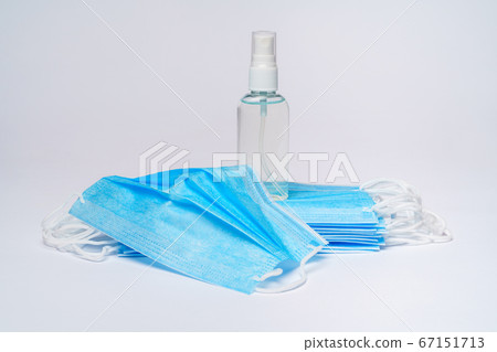 bottle of lotion, sanitizer or liquid soap and protective mask over light grey background 67151713