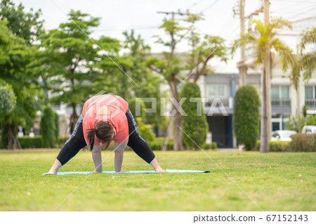new normal concept,Young woman is happy to motivation exercise or yoga outdoor in the garden to control or lose weight.Obese fat woman have intention exercise to lose weight and build strong health. 67152143