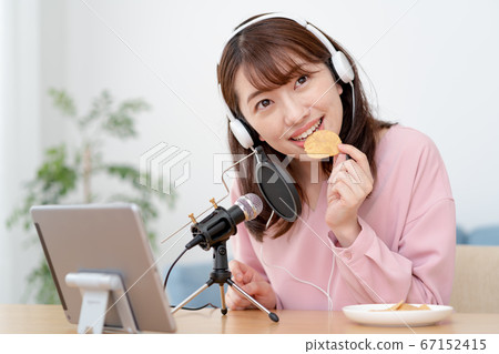 在YouTube上傳遞咀嚼聲音的年輕女子 在YouTube上傳遞咀嚼聲音的年輕女子 67152415