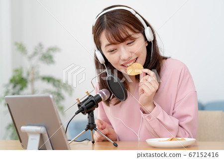 在YouTube上傳遞咀嚼聲音的年輕女子 在YouTube上傳遞咀嚼聲音的年輕女子 67152416