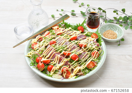 Katsuo sashimi, mayonnaise salad style arrangement. Spicy bonito sashimi with plenty of vegetables such as leeks and cherry tomatoes Katsuo sashimi, mayonnaise salad style arrangement. Spicy bonito sashimi with plenty of vegetables such as leeks and cherry tomatoes 67152658