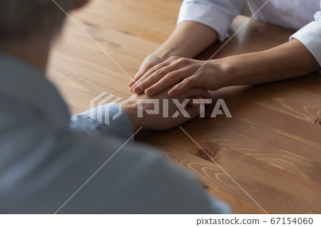Close up of caring female nurse touch male patient hand 67154060