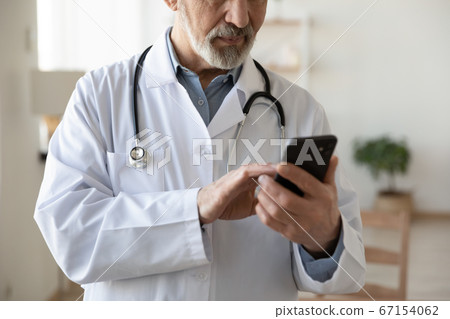 Close up of old male doctor consult patient on gadget 67154062