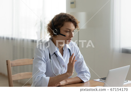 Woman doctor in headset have video call on computer Woman doctor in headset have video call on computer 67154170