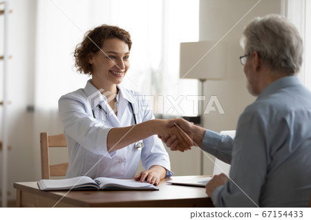 Smiling female doctor handshake elderly patient at consultation Smiling female doctor handshake elderly patient at consultation 67154433