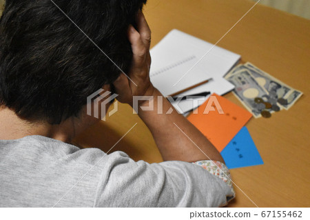 中年婦女抱著頭計算養老金 中年婦女抱著頭計算養老金 67155462