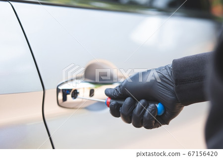 Robbers are stealing cars in the parking lot 67156420