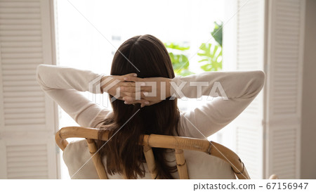 Rear view calm dreamy woman relaxing in cozy chair Rear view calm dreamy woman relaxing in cozy chair 67156947
