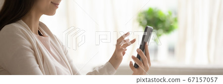 Satisfied young woman holding smartphone, using mobile device app 67157057