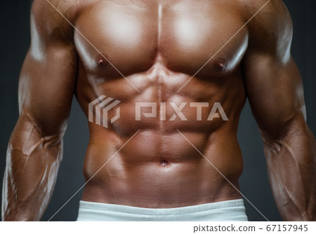 Fitness man pumping up abs muscles in gym 67157945