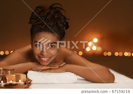 Portrait of cheerful african woman enjoying spa 67159219