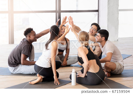 Happy multiethnic people giving high five to each other after fitness training Happy multiethnic people giving high five to each other after fitness training 67159504