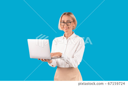 Online work. Successful office employee holding laptop computer on blue background 67159724