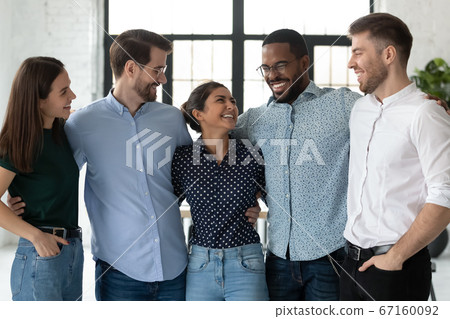 Excited diverse colleagues hugging joking enjoy meeting and friendship Excited diverse colleagues hugging joking enjoy meeting and friendship 67160092