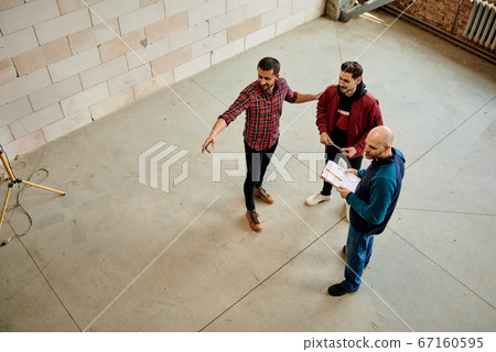 Young succesful worker touching one of colleagues while pointing forwards 67160595
