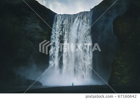Hiker at gigantic Skogafoss waterfall in Iceland 67160642