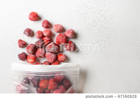 Frozen strawberries in plastic packet on white. 67160828