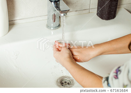 Close-up girls hands while washing with running water Close-up girls hands while washing with running water 67161684