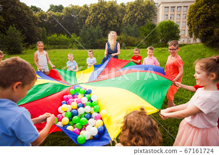 Close view colorful parachute with balls. Kids in circle Close view colorful parachute with balls. Kids in circle 67161724