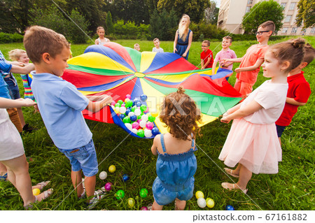 Cheerful children playing outdoors at birthday party 67161882