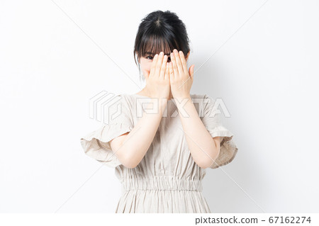 Young woman hiding her face 67162274