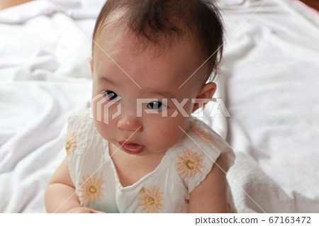 Baby sitting in the living room 67163472