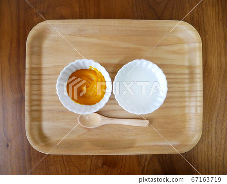 嬰兒食品的南瓜和稀飯放在木托盤上 嬰兒食品的南瓜和稀飯放在木托盤上 67163719