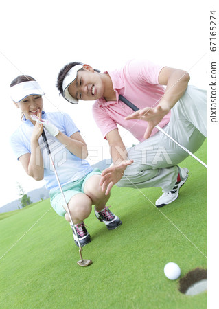 A couple playing golf 67165274