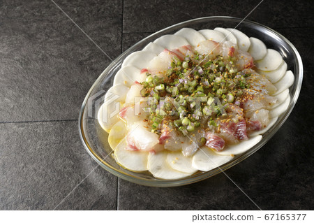 Carpaccio of sea bream and turnips on a transparent flat plate 67165377