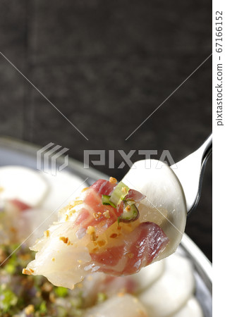 Eat the sea bream and turnip carpaccio on a transparent flat plate 67166152