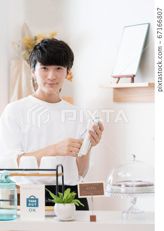 A man working as a cafe clerk [takeout] 67166807