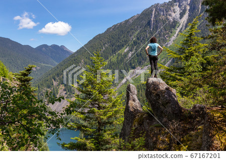 Girl on Top of Cliff with Beautiful View of Canadian Mountain Landscape 67167201