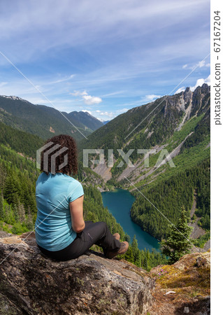 Girl on Top of Cliff with Beautiful View of Canadian Mountain Landscape 67167204