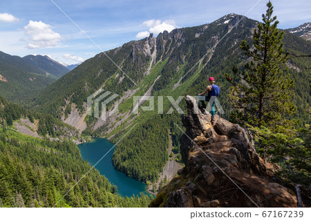 Girl on Top of Cliff with Beautiful View of Canadian Mountain Landscape Girl on Top of Cliff with Beautiful View of Canadian Mountain Landscape 67167239