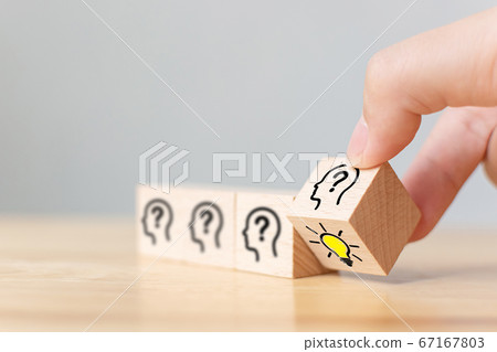 Hand puttung wooden cube block flip over with head human symbol and light bulb icon 67167803