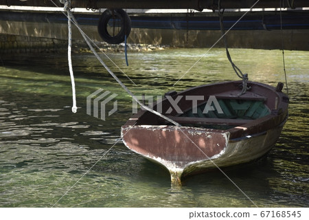 On the surface of the sun-irradiated river, on the surface of a ship with a small boat. 67168545