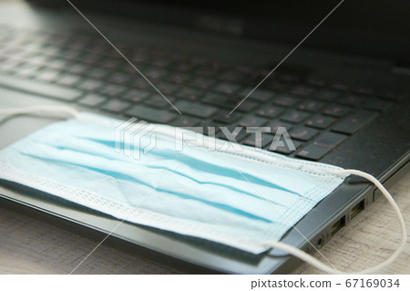 medical mask on a black laptop keyboard. medical equipment and remote work medical mask on a black laptop keyboard. medical equipment and remote work 67169034