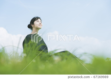 A woman relaxing in the meadow A woman relaxing in the meadow 67169989