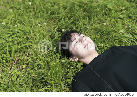 A woman relaxing in the meadow 67169990