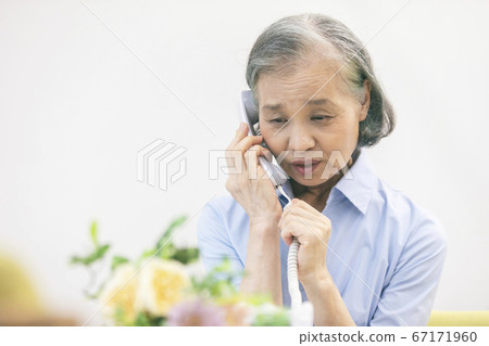 Senior woman talking on landline phone Senior woman talking on landline phone 67171960