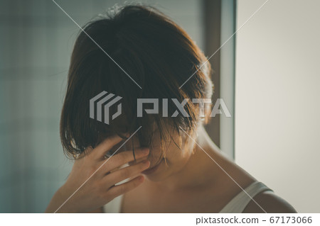 一個年長的女人低頭看 67173066