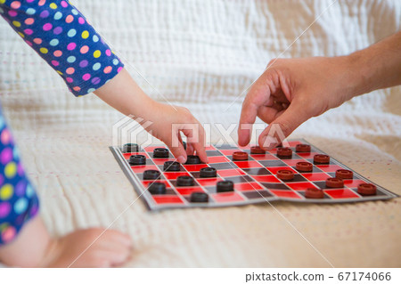 checkers close-up. black and red map. the hand holds the chip. games for development of logic checkers close-up. black and red map. the hand holds the chip. games for development of logic 67174066