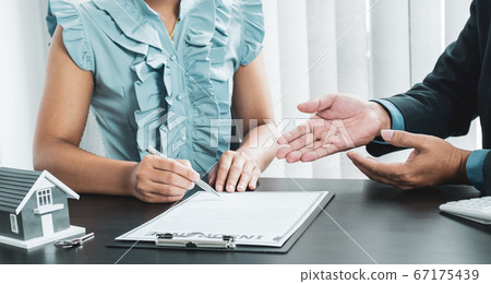 The buyer is signing a contract for business rental, mortgage purchase, or home insurance in front of a real estate agent The buyer is signing a contract for business rental, mortgage purchase, or home insurance in front of a real estate agent 67175439