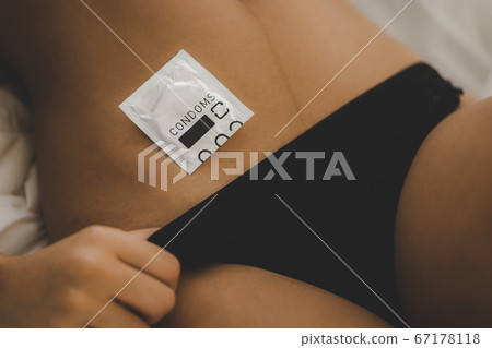 Condom lying on woman body for sexual protection Condom lying on woman body for sexual protection 67178118
