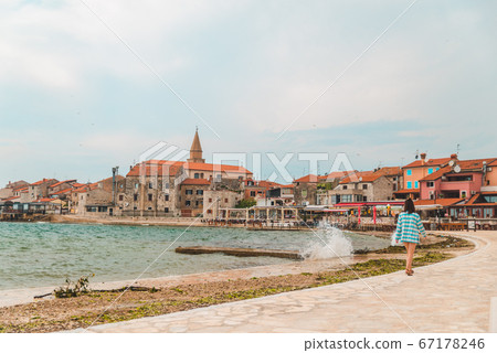 woman walking by umag city quay at stormy weather. copy space woman walking by umag city quay at stormy weather. copy space 67178246